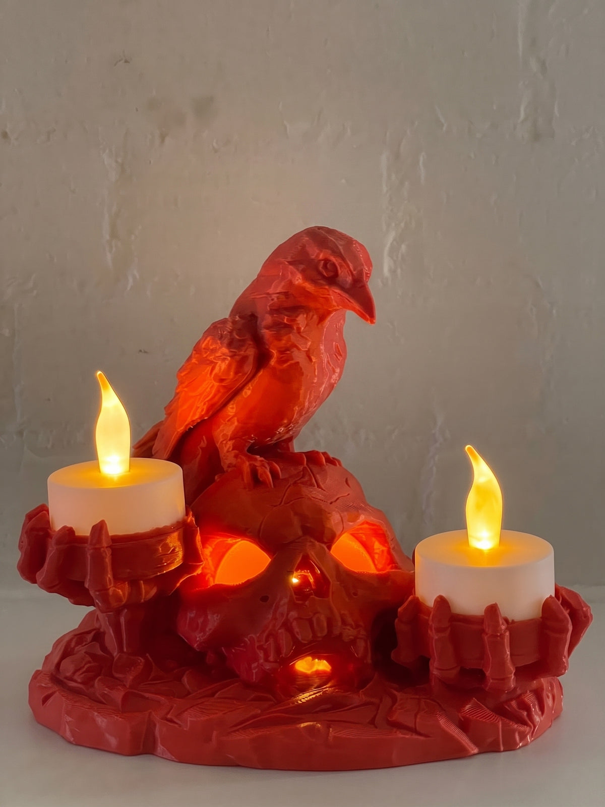 Red Halloween skull and raven candle holder with illuminated skull and three warm LED candles.
